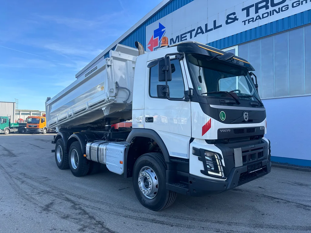 Weißer Volvo-Kipper vor der Halle von R. Metall & Truck Trading.