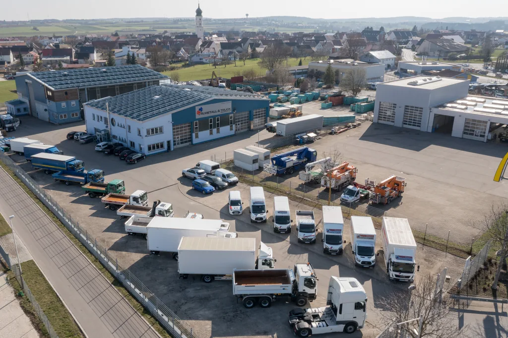 Luftaufnahme des Betriebsgeländes in Merklingen mit Hallen, Fahrzeugen und Zufahrt.